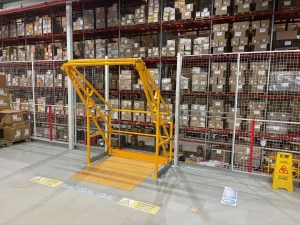 Yellow pallet gate on a mezzanine floor with mesh panels in Castleford