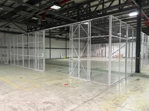3.66m high mesh partitioning stores area with a full height sliding door in Norwich