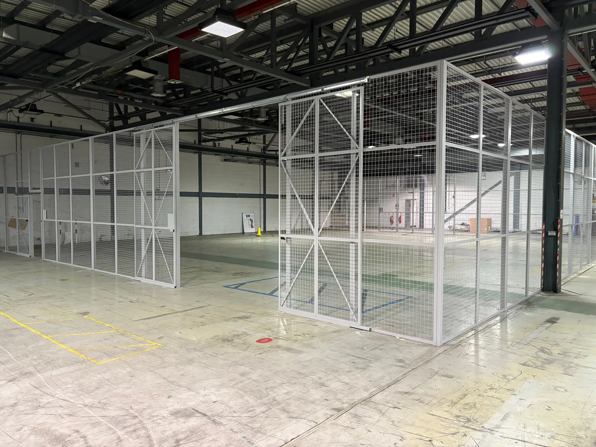 3.66m high mesh partitioning stores area with a full height sliding door in Norwich